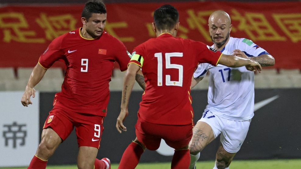  الصينيان وو شي والكيسن يتواجهان مع اللاعب الفلبيني ستيفان شروك خلال المباراة المؤهلة لكأس العالم 2022 على استاد الشارقة. 7 حزيران (يونيو) 2021