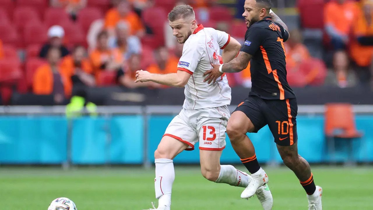 مهاجم هولندا ممفيس ديباي (يمين) في صرع على الكرة مع لاعب مقدونيا لاشمالية ستيفان ريستوفسكي في لقاء الفريقين في كأس اوروبا 2020. 21 حزيران/يونيو 2021.