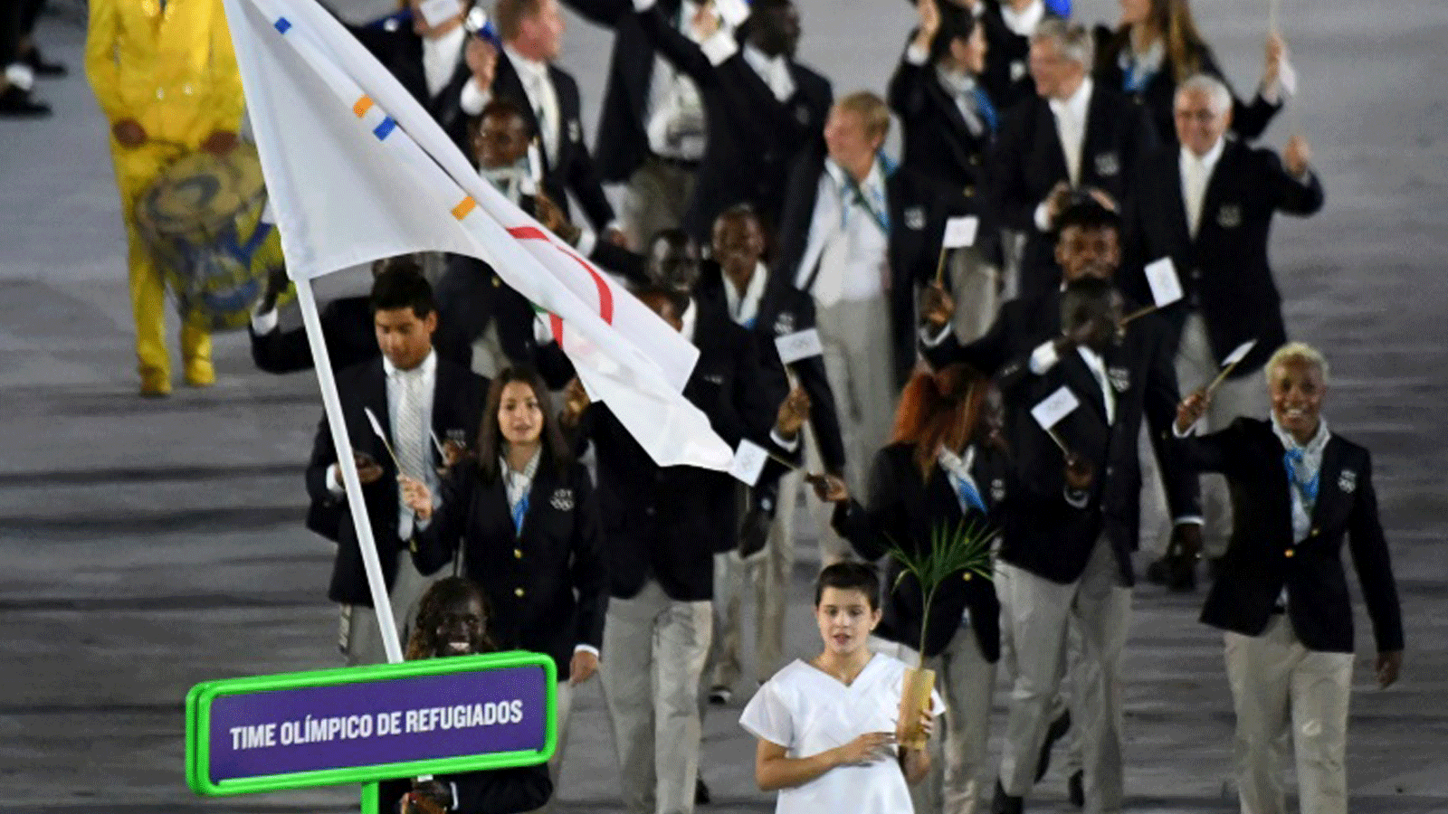 روز لوكونين من جنوب السودان (إلى أسفل يسار الصورة) تحمل العلم الأولمبي لوفد اللاجئين في أولمبياد ريو في 5 آب/أغسطس 2016
