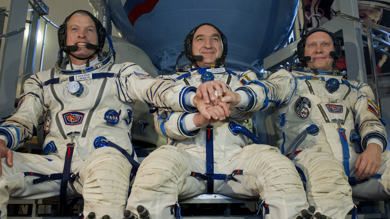 رائد فضاء ناسا ستيفن سوانسون (يسار) يتدرب مع رواد الفضاء ألكسندر سكفورتسوف (في الوسط) وأوليج أرتيمييف (يمين) قبل انطلاقهم في آذار/مارس 2014 إلى المحطة الفضائية