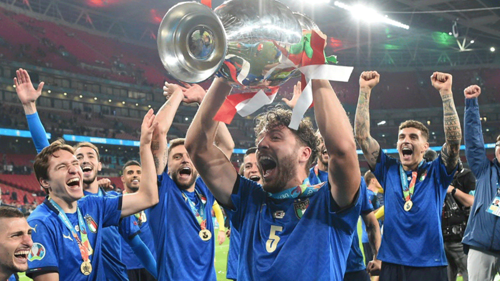 مانويل لوكاتيلي يحمل كأس أوروبا محتفلاً مع زملائه في المنتخب الإيطالي بعد الفوز باللقب على حساب إنكلترا في 11 تموز/يوليو 2021
