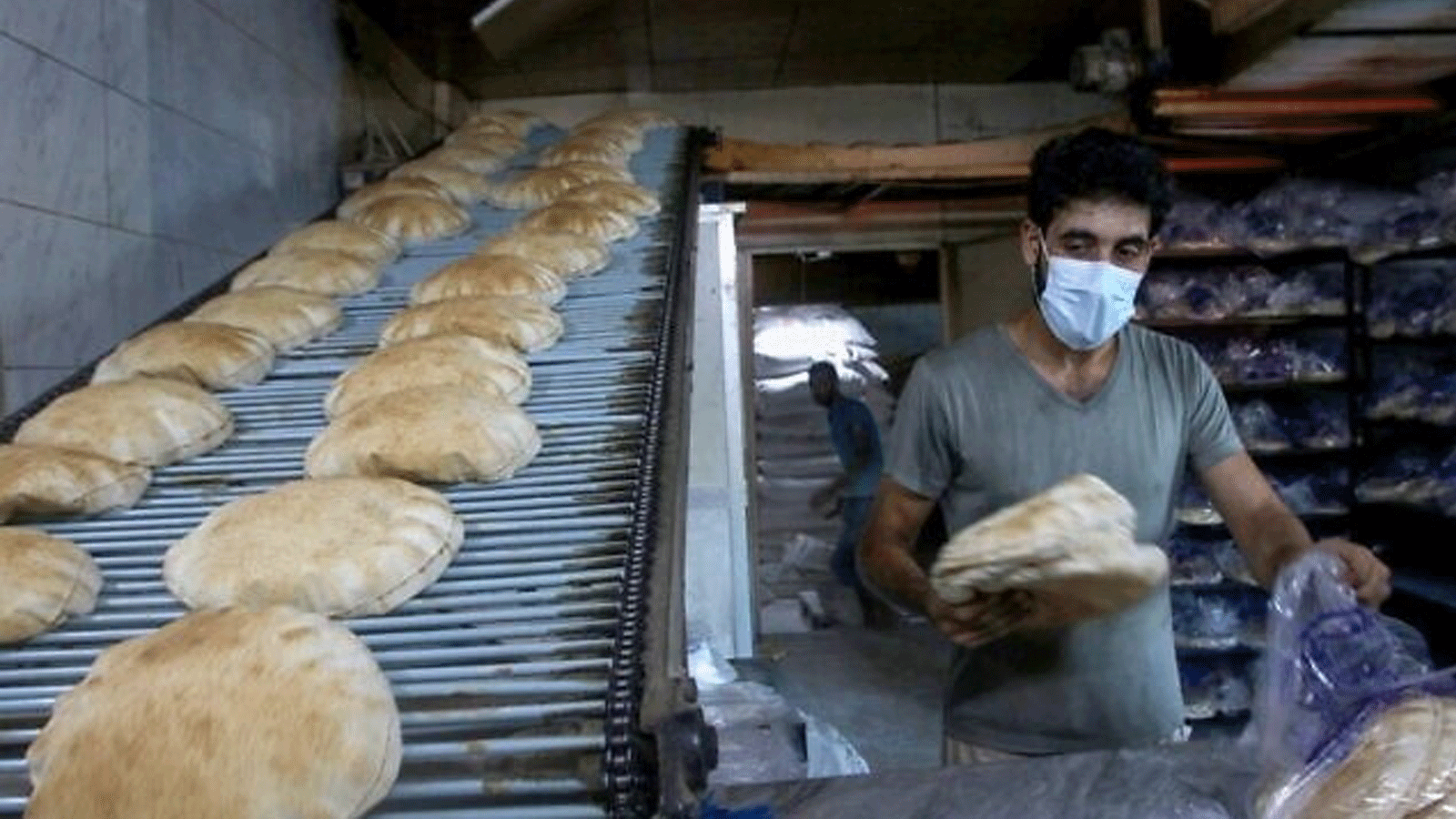 خبازون يعبئون الخبز الأبيض الطازج في أكياس. في 13 آب/ أغسطس 2021