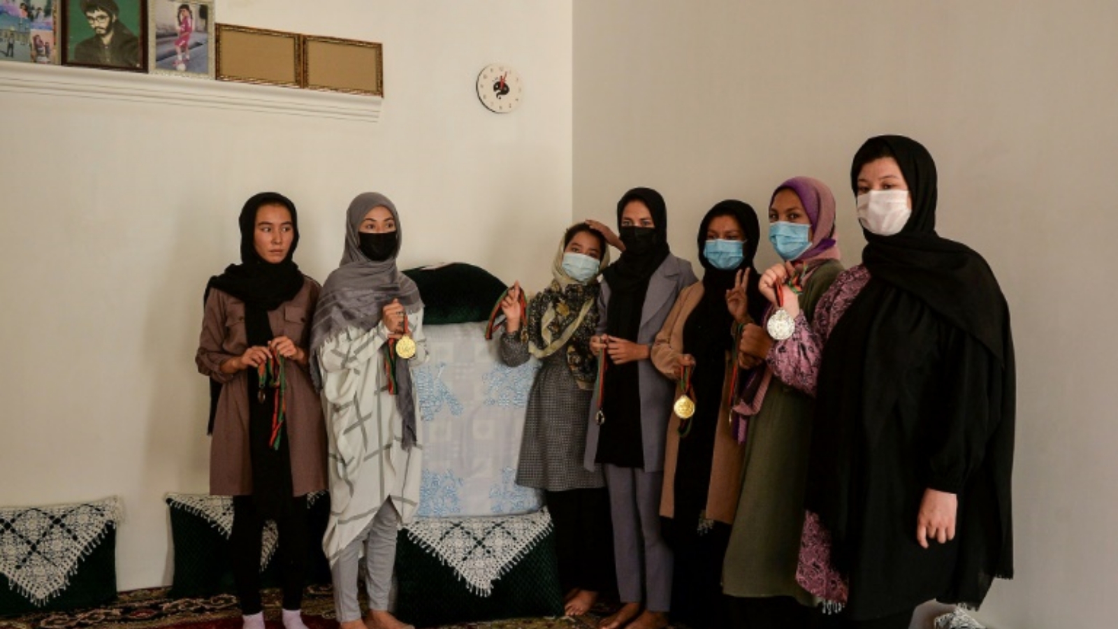 البطلة الأفغانية زرغونة نوري (يسار) تقف مع زميلاتها في أكاديمية التايكواندو الأفغانية وميدالياتهن في منزل في مقاطعة هرات. في 22 أيلول/سبتمبر 2021.