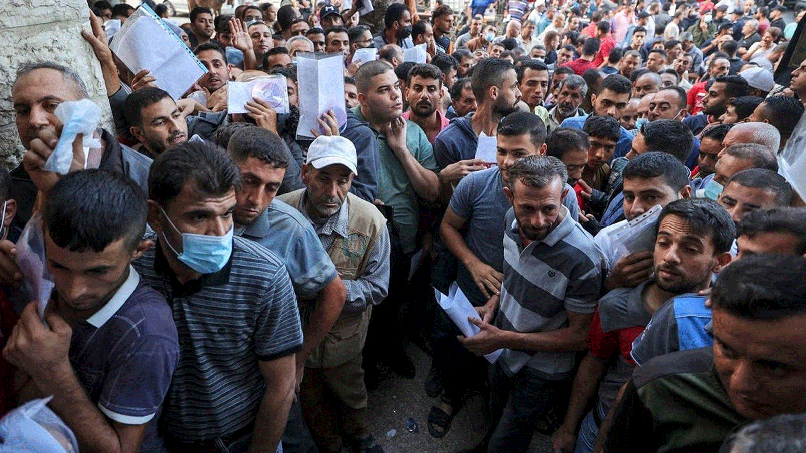  فلسطينيون يتجمعون لتقديم طلبات الحصول على تصاريح عمل في إسرائيل، في مخيم جباليا شمال قطاع غزة. 6 تشرين الأول/أكتوبر2021