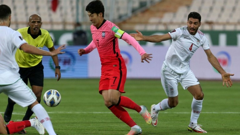 مهاجم كوريا الجنوبية سون هيونغ-مين (في الوسط) يسيطر على الكرة خلال لقاء فريقه أمام إيران ضمن منافسات المجموعة الاولى من التصفيات الآسيوية المؤهلة لمونديال قطر 2022 على ستاد آزادي في طهران في 12 تشرين الاوّل/أكتوبر 2021