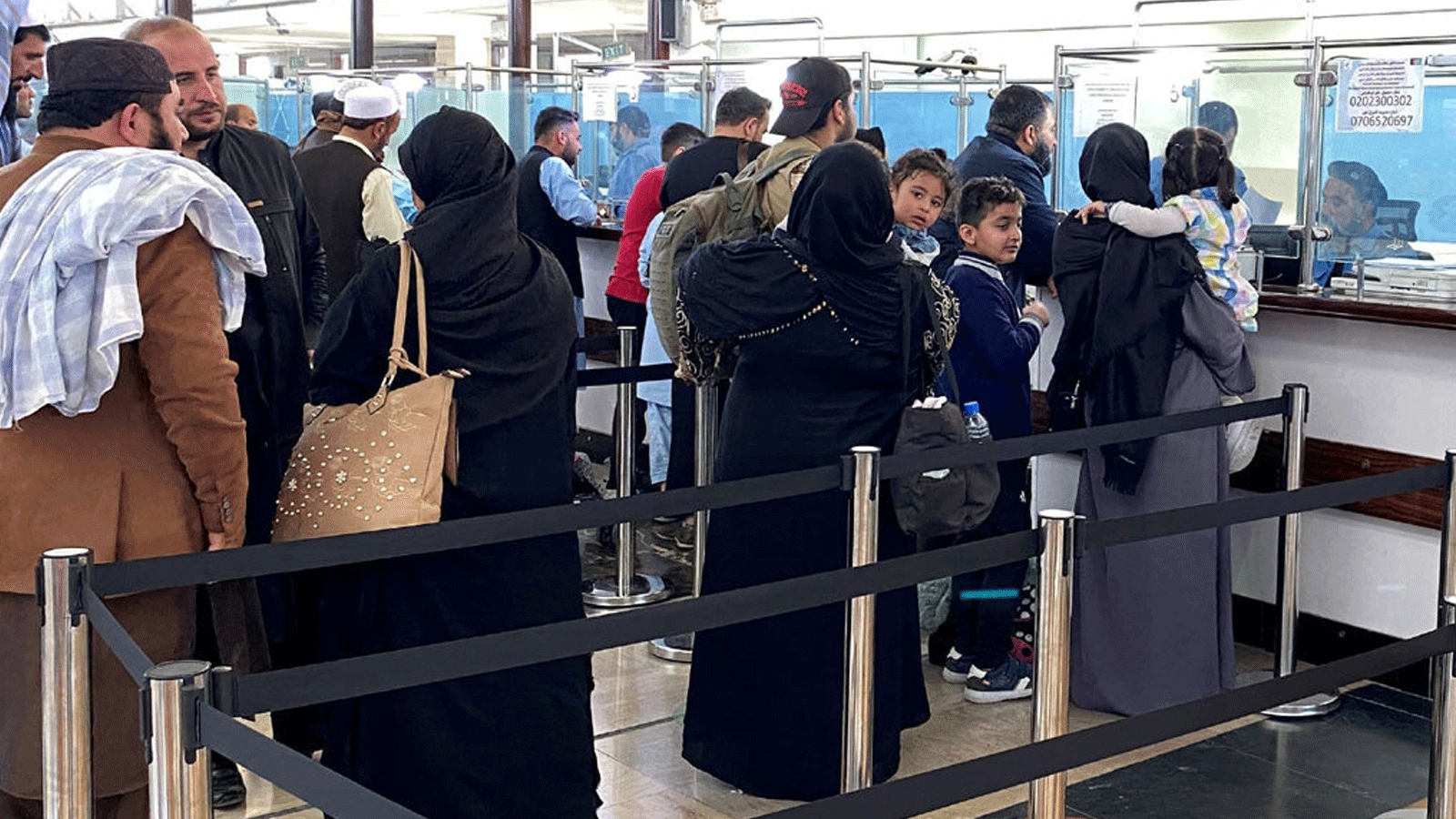 مجموعة من الرياضيين الأفغان وأفراد أسرهم ينتظرون للصعود على متن إحدى رحلات الخطوط الجوية القطرية المتجهة إلى الدوحة