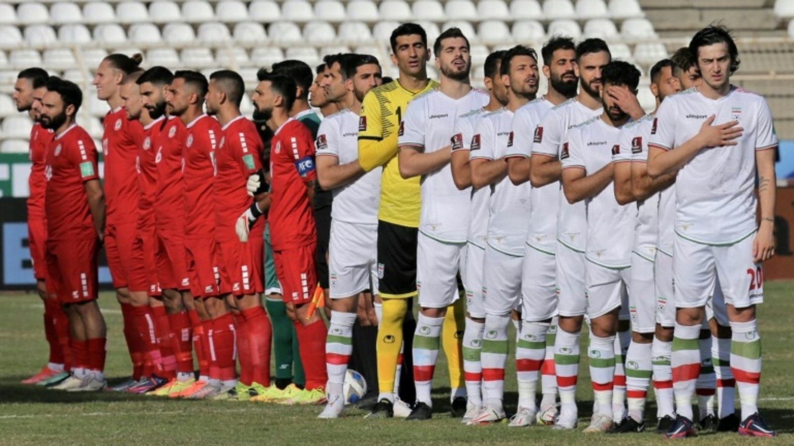 لاعبو المنتخب الإيراني لكرة القدم (بالزي الأبيض) أثناء عزف النشيد الوطني لبلادهم قبل مباراتهم ضد المنتخب اللبناني ضمن التصفيات الآسيوية المؤهلة إلى كأس العالم، في 11 تشرين الثاني/نوفمبر 2021.