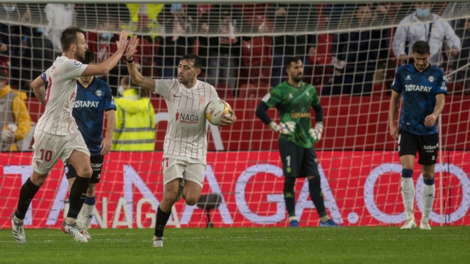 الكرواتي إيفان راكيتيتش (يسار) يحتفل مع وزميله منير الحدادي بتسجيل هدف التعادل لإشبيلية في مرمى ديبورتيفو ألافيس في المرحلة الرابعة عشرة من الدوري الإسباني لكرة القدم في 20 تشرين الثاني/نوفمبر 2021.