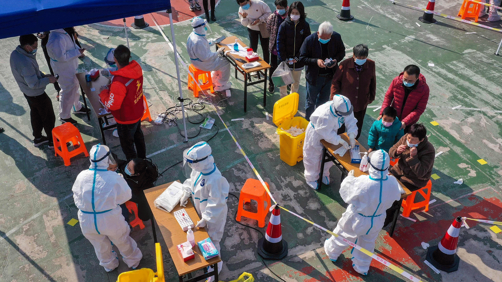 الناس ينتظرون الخضوع لاختبارات الحمض النووي لـ COVID-19 أثناء الاختبارات الجماعية في نينغبو، مقاطعة تشجيانغ، الصين. 7 كانون/ديسمبر 2021 