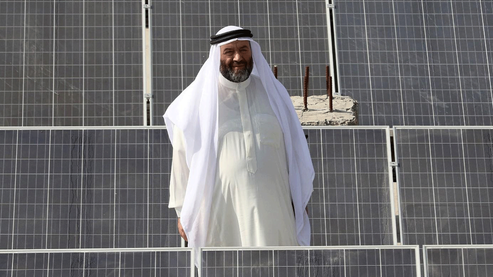 رجل يقف وسط ضفة من الألواح الشمسية في عمان. حيث سيوفر الأردن الطاقة الشمسية لإسرائيل التي ستقوم بتزويده بالمياه المحلاة.