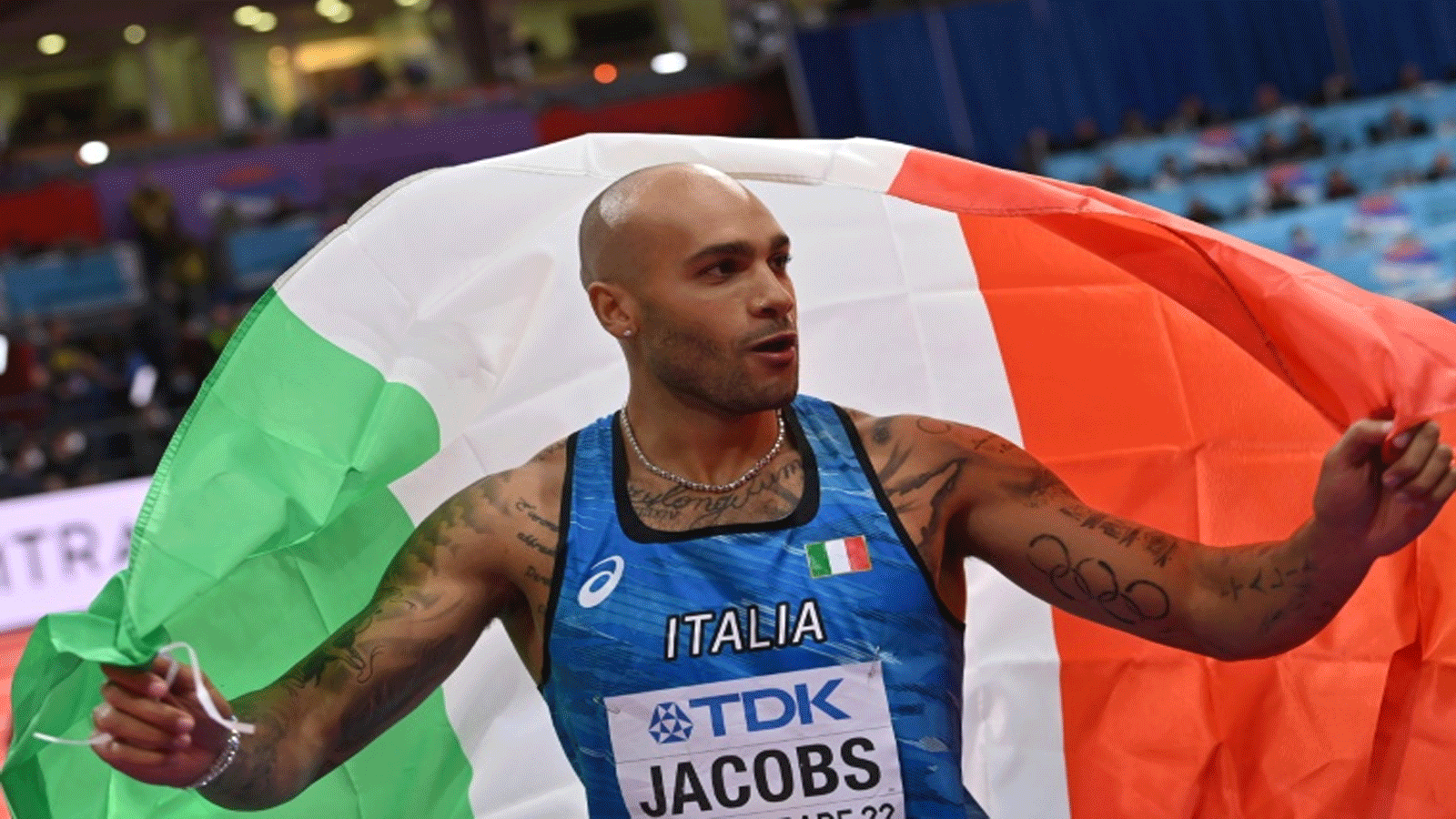 العداء الايطالي مارسيل جاكوبس يحتفل بتتويجه بلقب بطل العالم في سباق 60 م داخل قاعة في بلغراد في 19 آذار/مارس 2022.