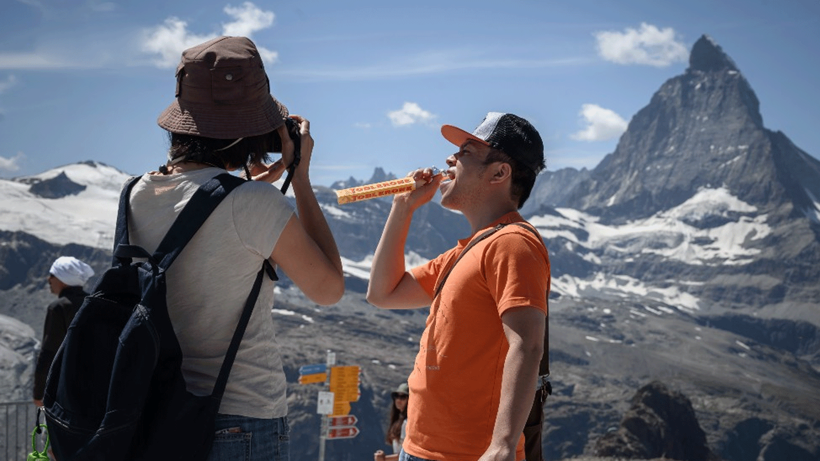 متسلقون يتناولون شوكولا توبليرون التي تحمل بتصميمها المثلثة شكل قمم جبال الألب.