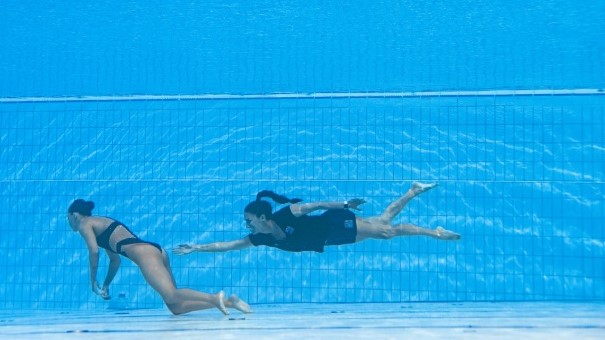 أندريا فوينتيس (يمين) مدربة الفريق الاميركي للسباحة الايقاعية تنقذ السباحة أنيتا ألفاريس بعد أن أغمي عليها خلال أدائها في بطولة العالم للسباحة في بودابست في 22 حزيران/يونيو 2022 