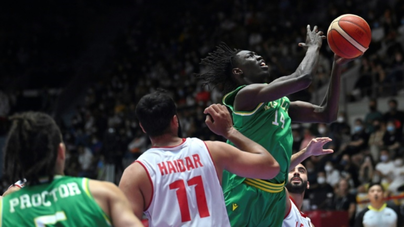 الأسترالي وينا دافيد أوكويرا (يمين) يرتقي إلى السلة تحت أنظار لاعب المنتخب اللبناني علي حيدر (رقم 11) خلال نهائي كأس آسيا لكرة السلة في جاكرتا. 24 يوليو 2022