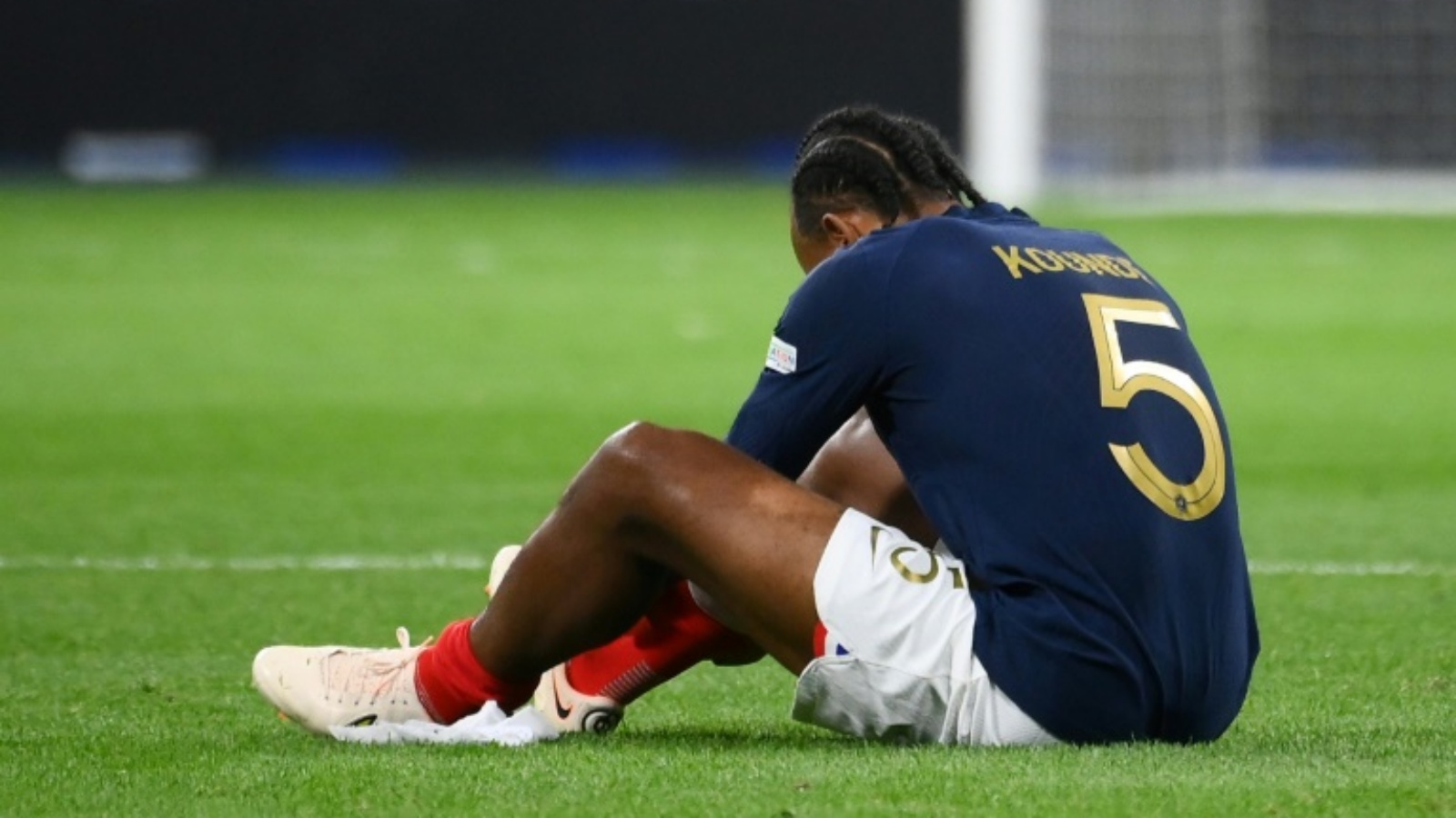 المدافع الفرنسي جول كونديه جالساً على الأرض بعد تعرضه لاصابة خلال مباراة منتخب بلاده أمام النمسا في مسابقة دوري الأمم الأوروبية