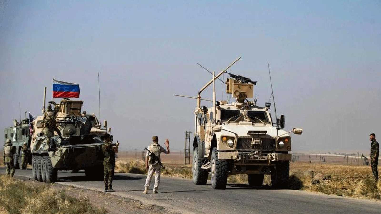 جنود دوريتين أميركية وروسية يتبادلون التحية أثناء تصادف مرورهم في القحطانية بمحافظة الحسكة شمال شرق سوريا. 8 تشرين الأول/أكتوبر 2022