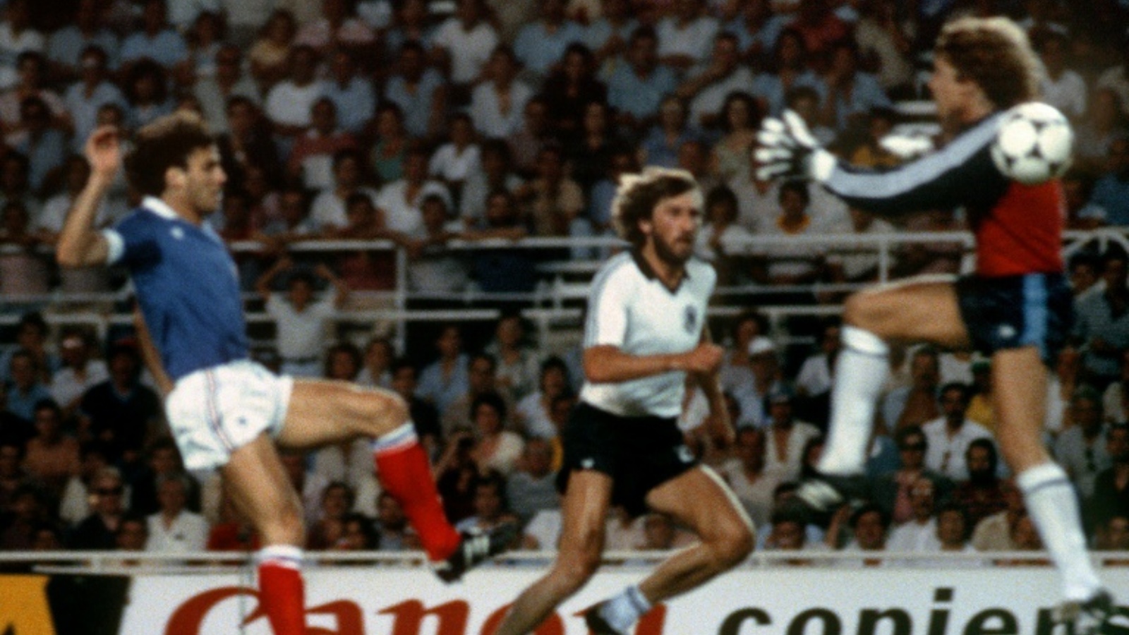 الحارس الألماني طوني شوماخر في طريقه نحو الفرنسي باتريك باتيستون خلال مباراة المنتخبين ضمن كأس العالم في كرة القدم 1982.