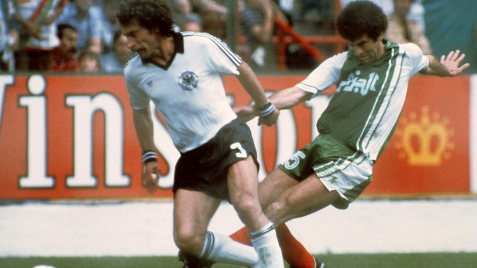 المدافع الألماني بول برايتنر (يسار) يحاول السيطرة على الكرة أمام الجزائري مصطفى دحلب في مونديال 1982 في خيخون