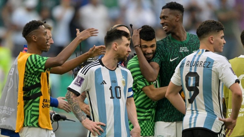 ميسي وزميله ألفاريز مهزومين وخلفهما أعضاء المنتخب السعودي يتبادلون التهاني بعد انتصار الأخضر على الأرجنتين 2 - 1 في مونديال قطر 2022