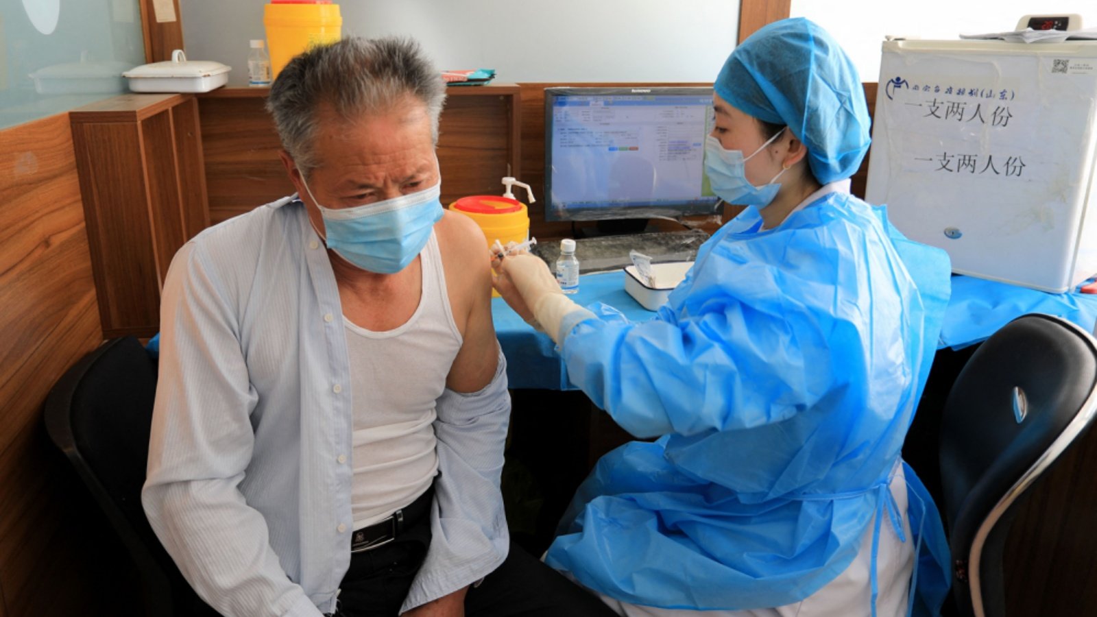 رجل مسن يتلقى جرعة لقاح فيروس كورونا في رونغتشينغ، الصين