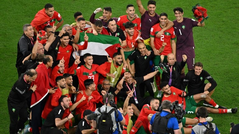 لاعبة المنتخب المغربي يحتفون بالفوز على اسبانيا بركلات الترجيح برفع العلم الفلسطيني على ملعب المدينة التعليمية في الدوحة في 6 كانون الأوّل/ديسمبر 2022