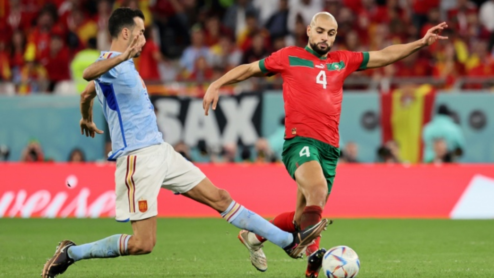 لاعب وسط المنتخب المغربي سفيان أمرابط يحاول تخطي لاعب وسط إسبانيا سيرجيو بوسكيتس في مباراة ثمن نهائي مونديال قطر في السادس من ديسمبر 2022