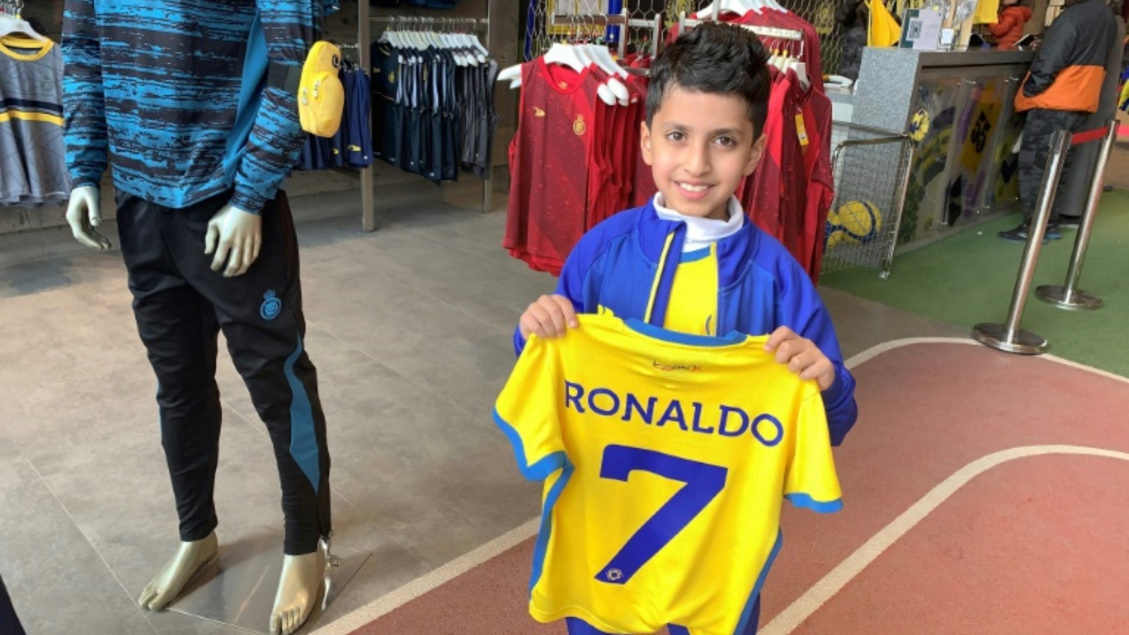 نايف العيبان (9 سنوات) يمسك قميص النصر السعودي الذي يحمل اسم رونالدو ورقم 7 في متجر النادي في الرياض في 31 ديسمبر 2022