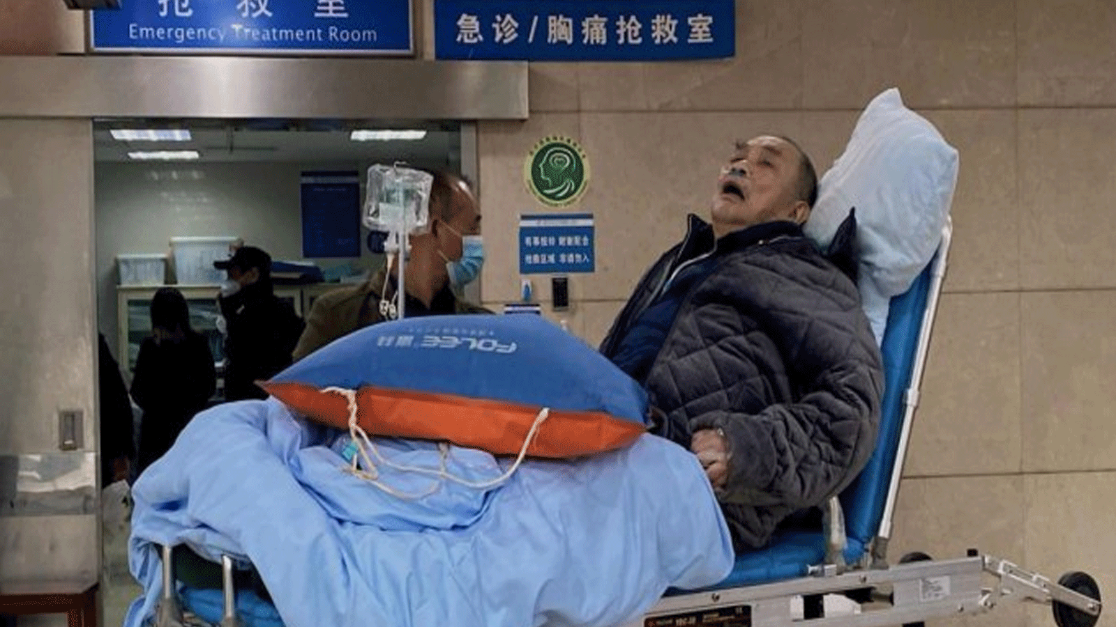 مريض مسن مصاب بفيروس كوفيد -19 مستلقي على نقالة في جناح الطوارئ في أول مستشفى تابع لجامعة تشونغتشينغ الطبية في مدينة تشونغتشينغ جنوب غرب الصين.