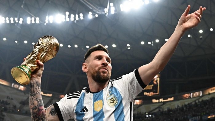 ليونيل ميسي يقف مع كأس العالم بعد فوز الأرجنتين على فرنسا بركلات الترجيح في النهائي