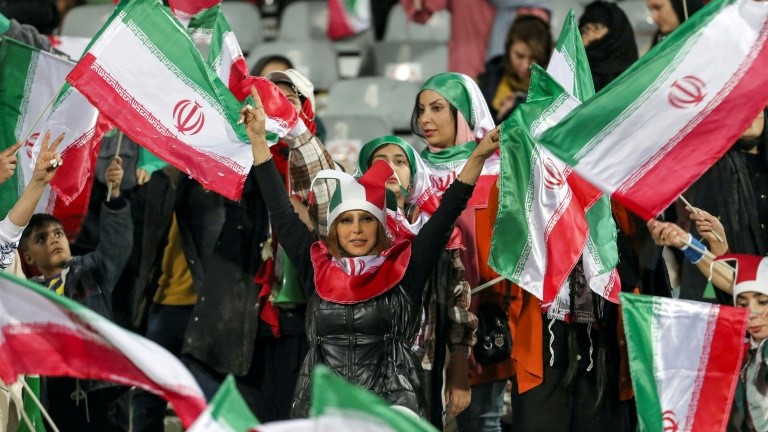 مشجعات إيرانيات يلوّحن بأعلام بلادهنّ خلال مباراة ودية مع روسيا على ملعب آزادي في العاصمة طهران. 23 آذار/مارس 2023