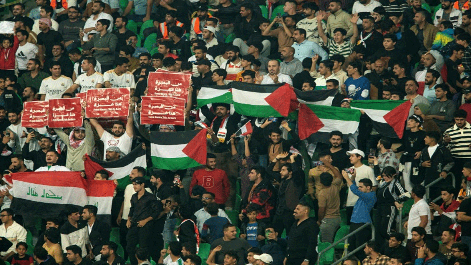مشجعون عراقيون يرفعون أعلام فلسطين خلال مباراة منتخب بلادهم أمام أندونيسيا في 16 تشرين الأول/نوفمبر 2023 في مدينة البصرة بجنوب العراق