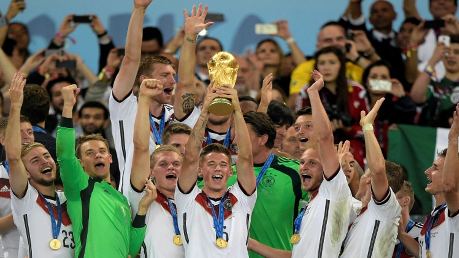 المدافع الألماني إريك دورم يحمل كأس العالم لكرة القدم 2014 عقب الفوز على الأرجنتين 1-0 بعد التمديد لشوطين إضافيين