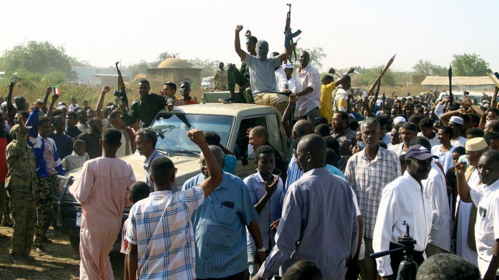 أنصار للمقاومة الشعبية المسلحة السودانية، التي تدعم الجيش، يرفعون أسلحتهم فوق شاحنة صغيرة خلال اجتماع بحاكم المدينة في القضارف بالسودان 16 كانون الثاني (يناير) 2024
