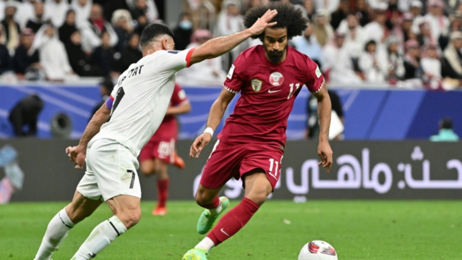 قائد فلسطين مصعب البطاط يحاول ايقاف القطري أكرم عفيف في ثمن نهائي كأس آسيا
