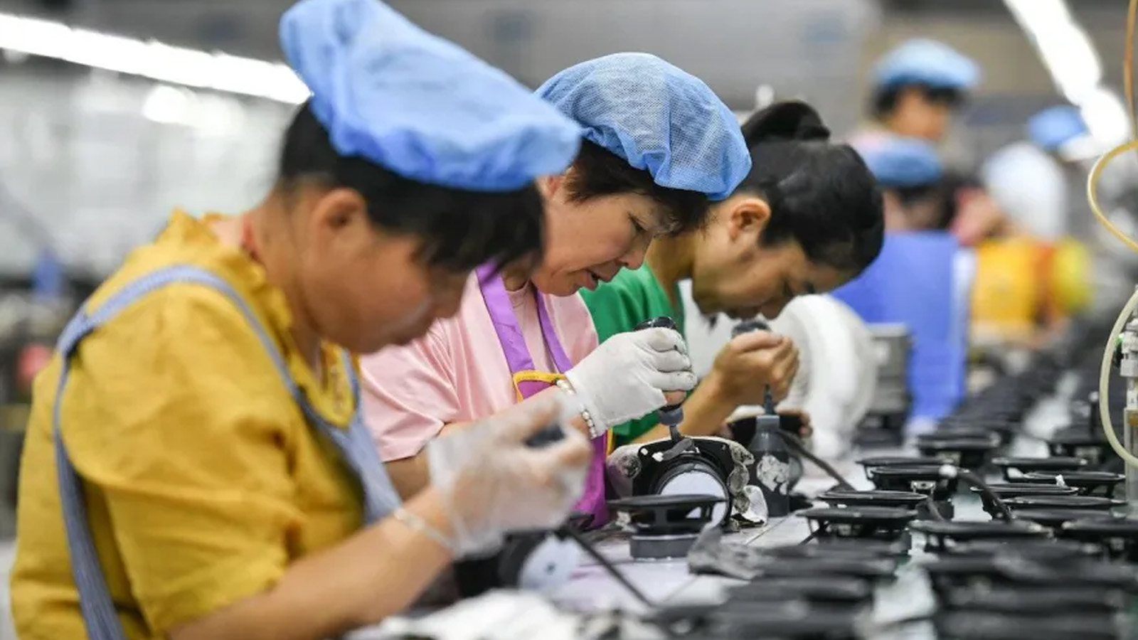 موظفون يعملون في خط تجميع ينتج مكبرات الصوت في مصنع في فويانغ بمقاطعة آنهوي شرق الصين