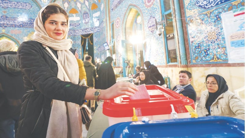 امرأة تدلي بصوتها في مركز اقتراع في طهران يوم الجمعة