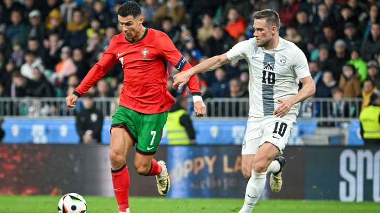 البرتغالي كريستيانو رونالدو (يسار) يقاتل على الكرة أمام السلوفيني تيمي إلشنيتش، خلال مباراة ودية بين منتخبيهما