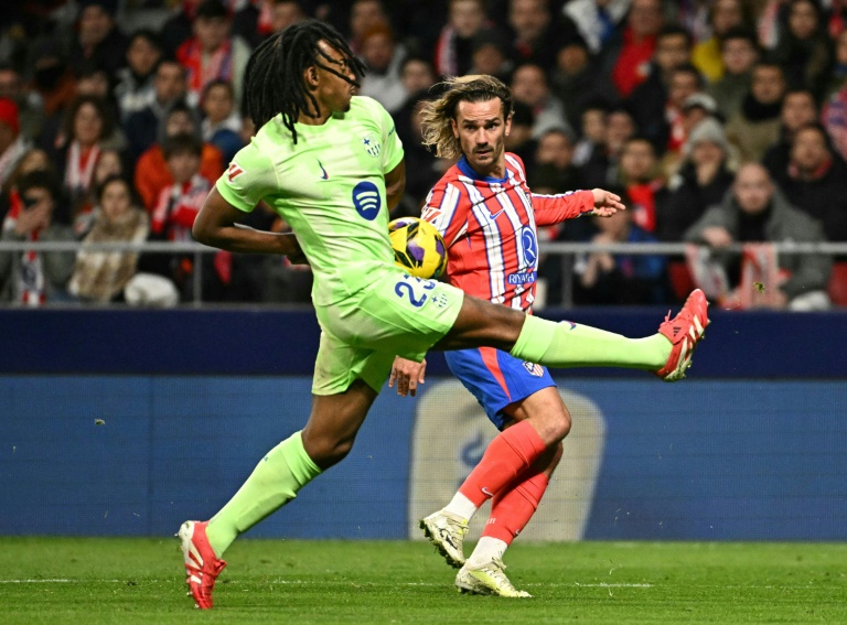 الفرنسي أنطوان غريزمان مهاجم أتلتيكو مدريد في صراع على الكرة مع مواطنه جول كونديه مدافع برشلونة على ملعب ميتروبوليتانو في مدريد، في 16 آذار/مارس 2025