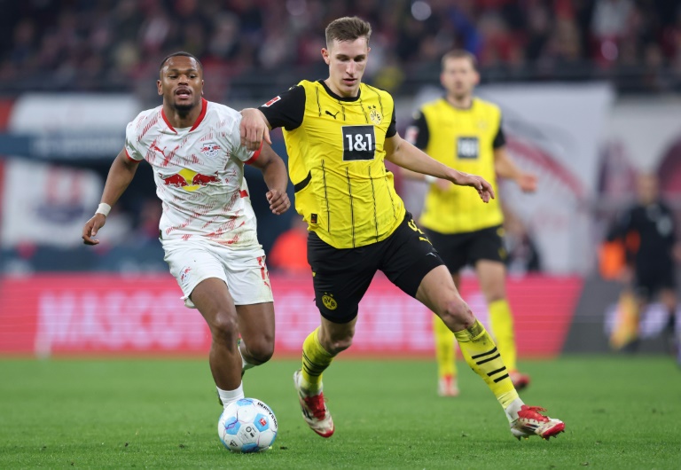 مدافع بوروسيا دورتموند نيكو شلوتربيك (يمين) يحاول انتزاع الكرة من المهاجم البلجيكي للايبزيغ لويس أوبندا خلال مباراة الفريقين في الدوري الألماني في لايبزيغ، شرق ألمانيا في 15 آذار/مارس 2025