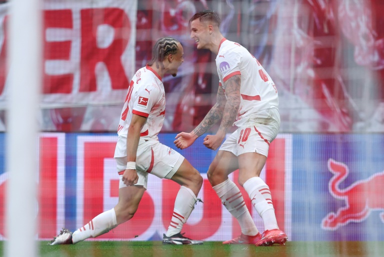 السلوفيني بنجامين شيشكو (يمين) يحتفل مع الهولندي تشافي سيمونز بالهدف الأول للايبزيغ في مرمى بايرن ميونيخ (3-3) في الدوري الألماني لكرة القدم. لايبزيغ، في 3 أيار/مايو 2025