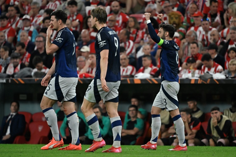 القائد البرتغالي لمانشستر يونايتد الإنكليزي برونو فرنانديش (يمين) يحتفل مع الدنماركي راسموس هويلوند (وسط) وهاري ماغواير بتسجيله الهدف الثالث في مرمى أتلتيك بلباو الإسباني في ذهاب نصف نهائي مسابقة 