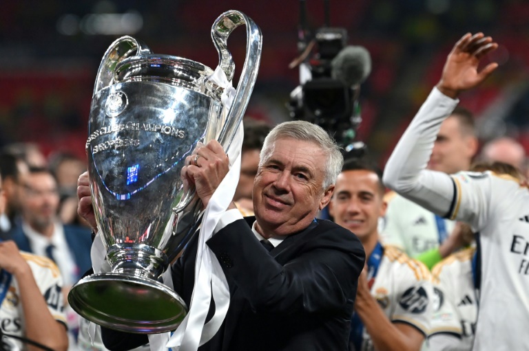 الإيطالي كارلو أنشيلوتي مدرب ريال مدريد الإسباني يحمل كأس دوري أبطال أوروبا بعد فوز فريقه في الأول من حزيران/يونيو 2024 في لندن
