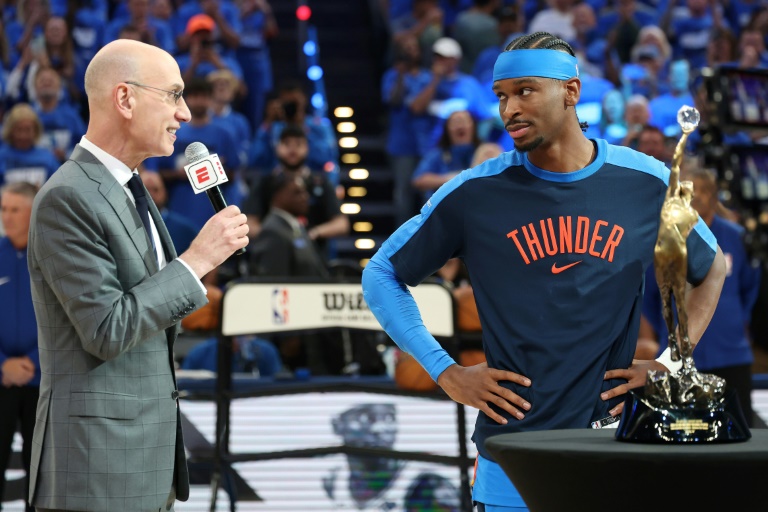 مفوض رابطة الدوري الاميركي للمحترفين في كرة السلة آدم سيلفر يسلم نجم اوكلاهوما سيتي ثاندر الكندي شاي غلجيوس الكسندر جائزة افضل لاعب في الدوري. 23 ايار/مايو 2025
