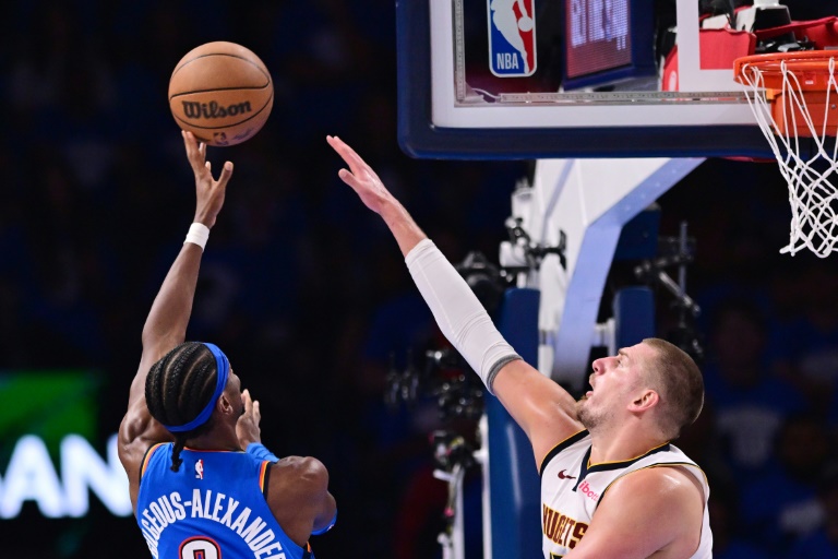 نجم أوكلاهوما سيتي ثاندر الكندي شاي غلجيوس-الكسندر (يسار) وسط تدخل ندجم دنفر ناغتس الصربي نيكولا يوكيتش في الدوري الاميركي للمحترفين في كرة السلة. 18 ايار/مايو 2025