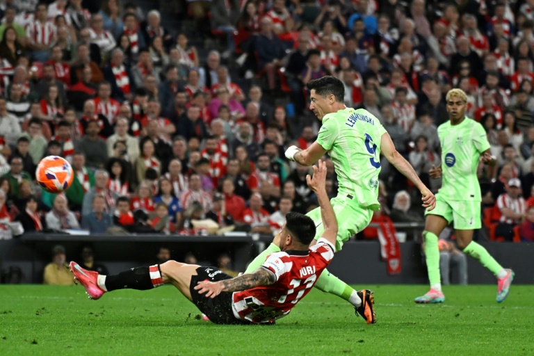 مدافع أتلتيك بلباو يوري بيرشيش يحاول التصدي لتسديدة مهاجم برشلونة البولندي روبرت ليفاندوفسكي على ملعب سان ماميس في بلباو، في 25 أيار/مايو 2025