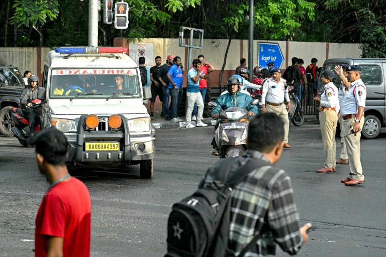 يفسح أفراد شرطة المرور الطريق لسيارة إسعاف بالقرب من ملعب إم. تشيناسوامي في بنغالورو في الرابع من بعد الإبلاغ عن وقوع إصابات في تدافع خلال الاحتفالات بفوز رويال تشالنجرز بنغالورو في المباراة النهائية للكريكيت في الدوري الهندي الممتاز في حزيران/يونيو 2025