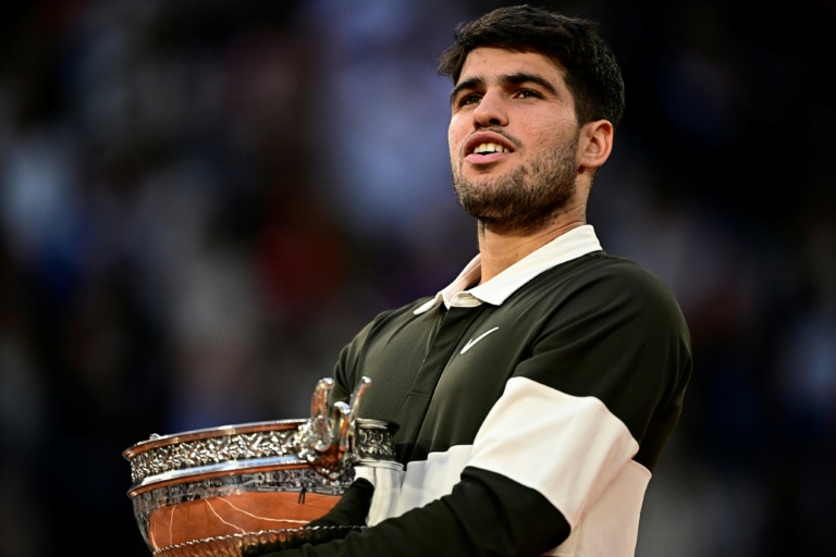 الاسباني كارلوس ألكاراس يحمل كأس بطولة رولان غاروس المتوج بها على حساب الايطالي يانيك سينر في باريس في الثامن من حزيران/يونيو 2025