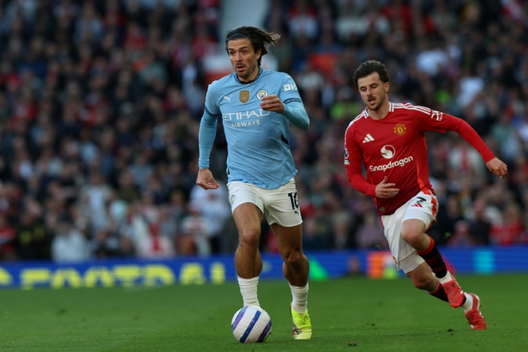 الجناح الإنكليزي لمانشستر سيتي جاك غريليش ينطلق بالكرة بعيدا عن مواطنه لاعب مانشستر يونايتد مايسون ماونت خلال مواجهة الفريقين ضمن الدوري الإنكليزي لكرة القدم. ملعب أولد ترافورد في مدينة مانشستر، شمال غرب إنكلترا. في السادس من نيسان/أبريل 2025.