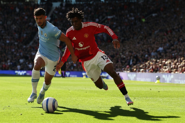 المدافع الدولي الدنماركي لمانشستر يونايتد باتريك دورغو (يمين) يتنافس مع لاعب الوسط البرتغالي لمانشستر سيتي ماتيوس نونييش خلال دربي مانشستر ضمن الدوري الإنكليزي الممتاز على ملعب أولد ترافورد في مانشستر في السادس من نيسان/أبريل 2025
