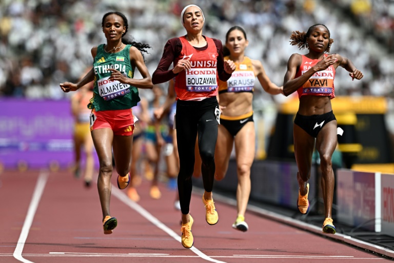 البحرينية وينفريد يافي (إلى اليمين) تجتاز خط نهاية تصفيات سباق 3 آلاف م موانع في المركز الاول إلى جانب التونسية مروى بوزياني (في الوسط) في بطولة العالم لألعاب القوى في طوكيو في 15 أيلول/سبتمبر 2025